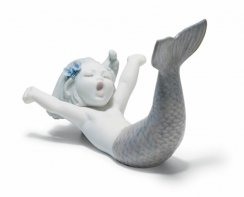 Figurita de sirena despierta en el mar. Azul