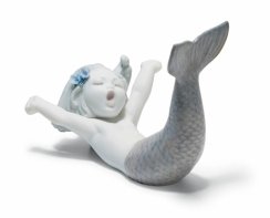 在海上醒来的美人鱼小雕像。紫色的